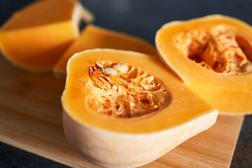 Pumpkin cut in half on wooden cutting board, closeup