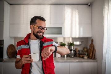 Paramedic man having coffee looking at smartwatch