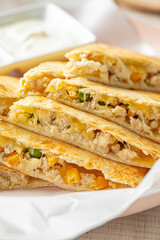 Mexican quesadilla with chicken, cheese, and vegetables served with salsa and sour cream