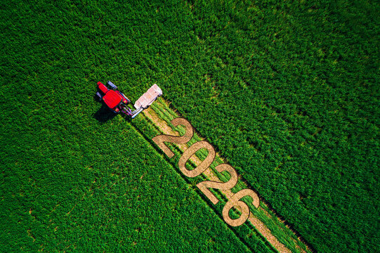 Aerial View Of Farmland Field with Working Red Tractor And Text 2026 Markings In Crops Agro background