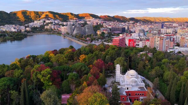 Aerial video of Tirana&rsquo;s Lake Park with the Amphitheatre and Saint Procopius Church at sunrise in autumn colors.