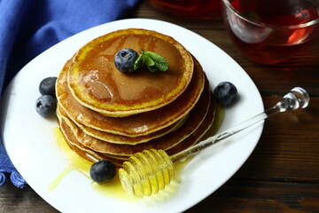 Tasty homemade pancakes with honey and berries