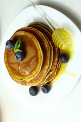 Tasty homemade pancakes with honey and berries