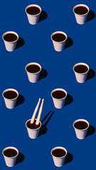 Paper coffee cups and plastic legs in bold pattern on blue background. Concept of cafe branding, pop-culture posts, creative menu art, graphic layouts and playful drink visuals.