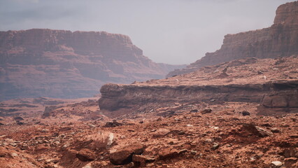 Breathtaking vistas reveal majestic cliffs and arid terrain under a hazy sky. The stark colors and textures paint a captivating scene in this remote wilderness. Explore the serenity.