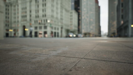 Early morning light bathes a quiet urban street corner, showcasing tall buildings and empty sidewalks. Cars are seen in the distance, hinting at a bustling day ahead.
