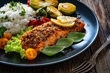 Baked salmon with white rice and Brussels sprouts on wooden table	