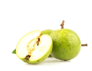 Green lucuma fruit cut open displaying its flesh on white surface