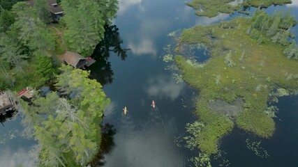 Drone overhead view of 2 kayakers paddling on a summer day on Rainbow Lake in the Adirondack Mountains in New York