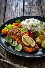 Baked salmon with white rice and Brussels sprouts on wooden table	