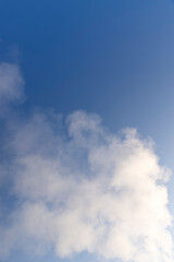 smoke from a wide pipe against a blue sky background, white steam coming from a pipe during heating of a large industrial premises in cold weather