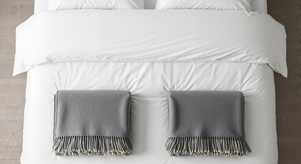 Perfectly made bed with a fresh white duvet cover and two neatly folded gray wool blankets