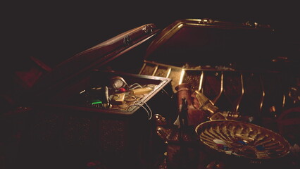 A treasure chest partially open, showcasing shimmering gold coins, ancient artifacts, and mysterious relics. The dim light casts shadows, highlighting the allure of forgotten history. © icetray