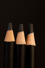 black wooden pencils on a black background, wooden pencils with graphite lead for drawing or other work