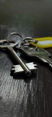Close-up of an old vintage key on a dark wooden table. Modern keys on a keyring with selective focus. Security and access concept