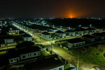 Aerial view of a neatly planned residential area glows under the soft streetlights, contrasting the dark night sky, Obirikwerre, Rivers, Nigeria.