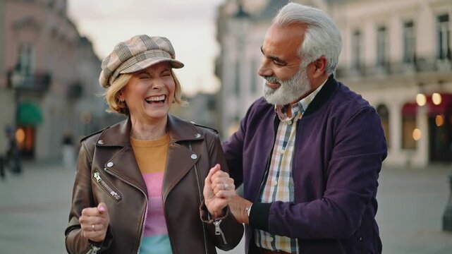 Happy senior couple having fun outdoor with city in background - Love, relationship and joyful elderly lifestyle concept - Models by AI generative - Powered by Adobe