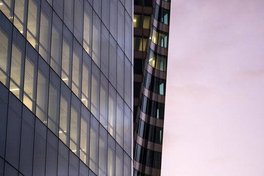 A modern design urban scene where architecture, corporate office windows and reflection highlight the dynamic blue hour facade at night for powerful branding uses