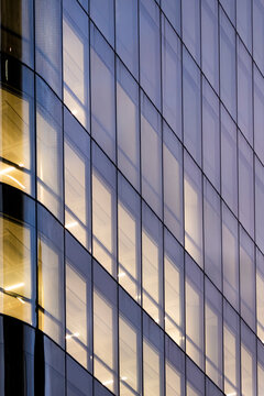 Corporate architecture with modern design office windows creating reflection across the urban facade during blue hour night settings for sleek business communication needs