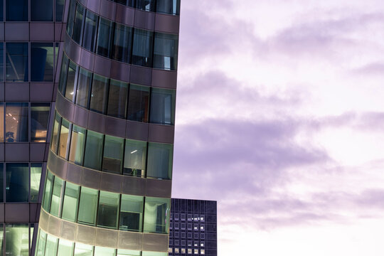 Reflection across architecture and corporate office windows defines this modern design facade in an urban blue hour night ideal for premium visual marketing narratives
