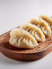 Small plate of dumplings on wooden board side view