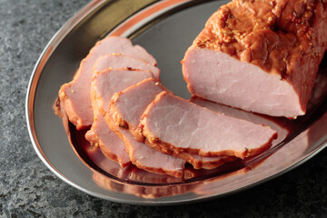 Delicious smoked ham on a metal tray.