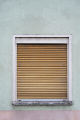 old window with closed wooden shutters, vertical format