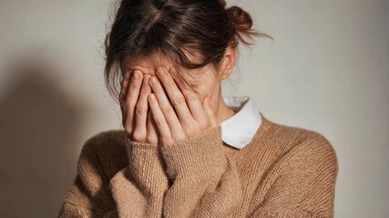 A young woman covering her face in emotion, expressing vulnerability and deep feelings. Ideal for mental health, storytelling, awareness, and emotional cinematic projects.