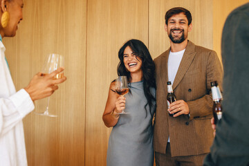 Cheerful group enjoying drinks and laughing in an indoor celebration