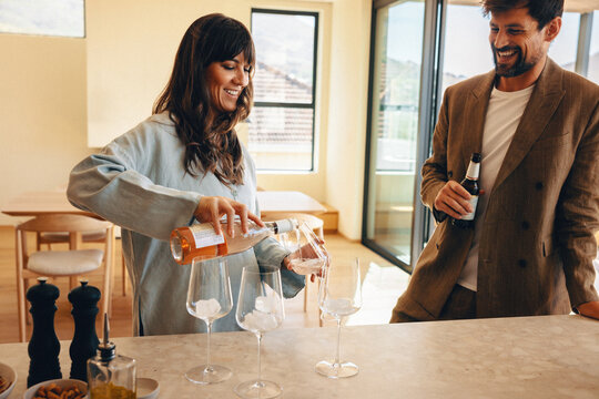 Man and woman enjoying drinks together in a modern home - Powered by Adobe