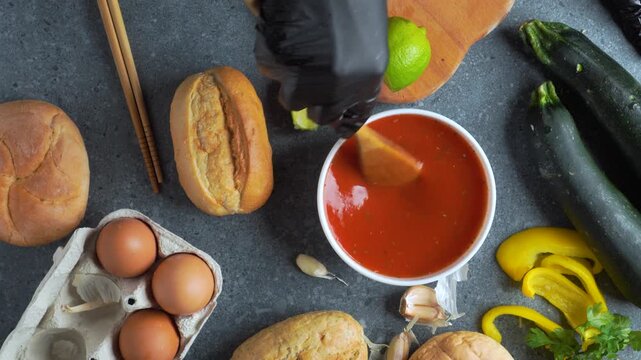 Flatlay video of chef preparing tomato sauce in white bowl with assorted ingredients