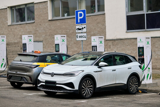 Minsk, Belarus. Jan 19, 2025. VW and BYD Taxi electric cars charging. Electric vehicles plugged into charging station in parking lot, modern technology, sustainable energy use. E-SUV charging battery