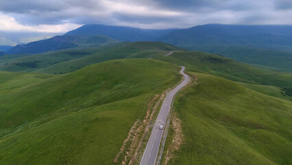 The car is driving along a road in the Caucasus Mountains to the Dzhila-Su Valley