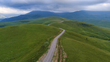 The car is driving along a road in the Caucasus Mountains to the Dzhila-Su Valley