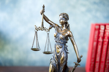 Statue of Themis Lady of Justice symbol on grey background.