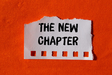The new chapter message written on ripped torn paper background. Conceptual The new chapter symbol....