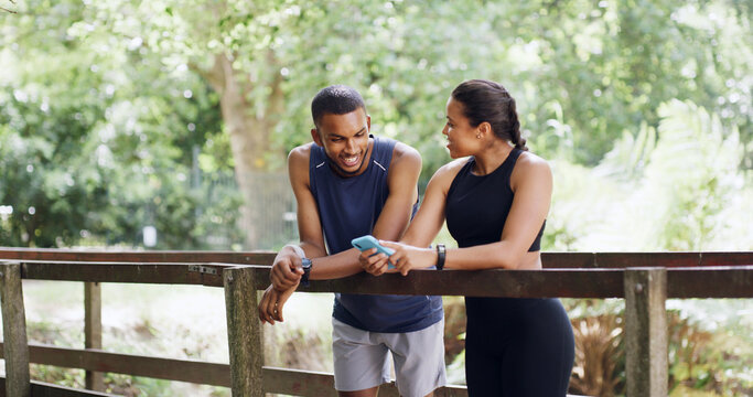 Bridge, smile and couple with cellphone, workout and bonding together with social media. Funny meme, outdoor and man with healthy woman, talking and smartphone with training, internet and digital app
