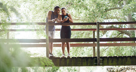 Bridge, smile and couple with cellphone, fitness and bonding together with social media. Funny meme, outdoor and man in park, healthy woman and smartphone with training, laughing and digital app