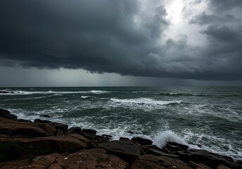 Dramatic, stormy seascape featuring dark, heavy clouds covering the sky over a churning gray ocean with rough waves crashing against a rugged shoreline ,foam ,turbulent ,somber