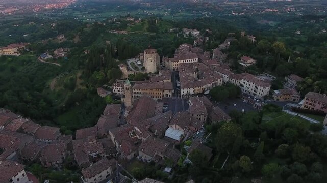 Aerial view of the buildings and trees of Asolo, where the red rooftops contrast with the lush green vegetation, Asolo, Veneto, Italy.