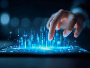 Human hand interacting with futuristic digital holographic data projections emerging from a tablet screen in a dark technology environment concept