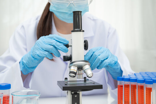 Scientist medical professional use microscope for research in science laboratory.