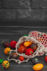 Assortment of various tomatoes in a trendy eco bag. Handmade, crocheted, zero-waste concept