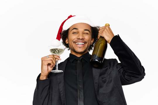 Young man in elegant attire celebrates with drinks during festive season party