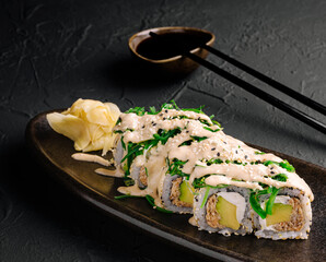 Delicious sushi rolls served on a dark plate with fresh toppings