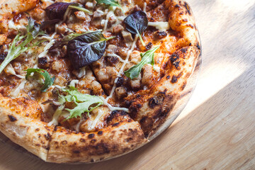 Smoked Bacon Pizza thin crust Homemade Style on wooden table atmosphere of relaxation with soft sunlight through shade of trees in from window.