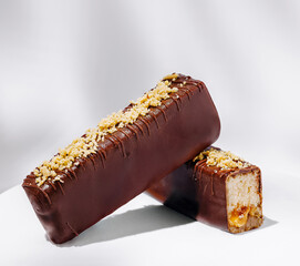 Chocolate-covered dessert bars with nut topping and soft filling