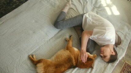 woman kneeling on bed petting shiba, soft sunlight, cozy rug, calm nurturing touch, relaxed canine, gentle petting moment, tranquil setting where lady lovingly strokes her joyful pet on soft mattress