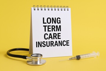 Long Term Care Insurance Concept with Stethoscope and Syringe on a Yellow Background