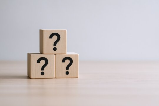 Three Wooden Blocks Stacked with Question Marks on Wooden Surface, Representing Uncertainty and Inquiry